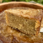 A slice of Jamaican Cornmeal Pudding with a coconut custard topping
